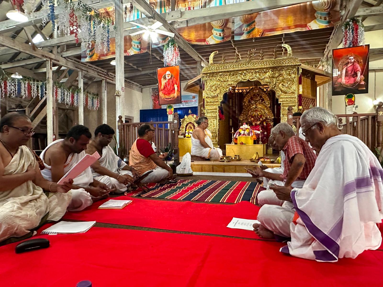Priests and devotees chanting in front of the shrine