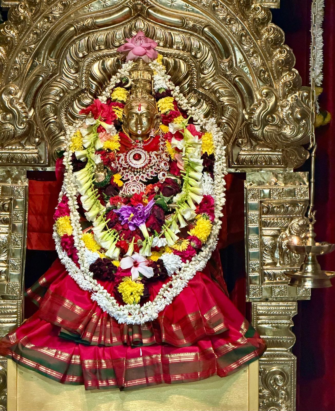 Deity adorned with silk and flower garlands
